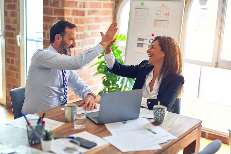 Equipo de profesionales celebrando un logro, reflejando compromiso y colaboración en nuestra inmobiliaria